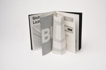 Stehendes offenes Zine mit Typografischen Bildern